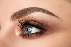 Close-up of woman eye with beautiful brown smokey eyes makeup